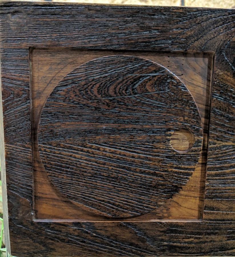 The DGA mark, a circle with an offset dot, carved into a dark timber panel